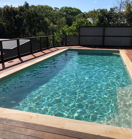 Pool on Wooden Deck with Fence — Pool Builders in Warana, QLD