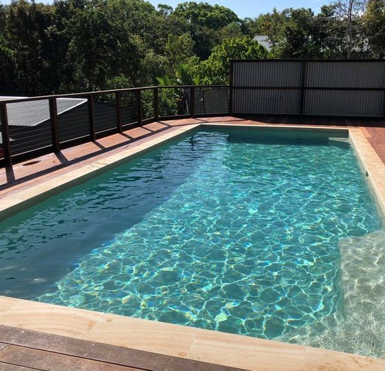 Pool on Wooden Deck with Fence — Pool Builders in Warana, QLD